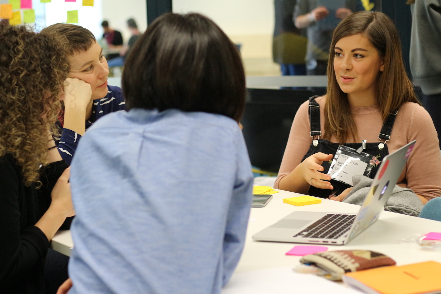 An image of 4 people in discussion at a table