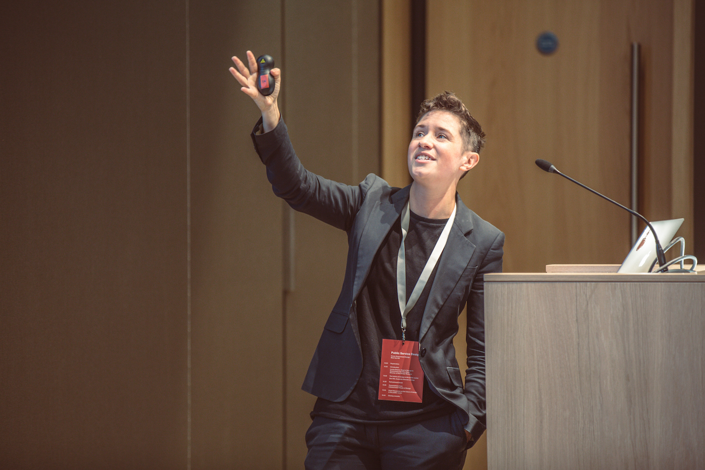 Lou standing at a lectern and gesturing at a screen