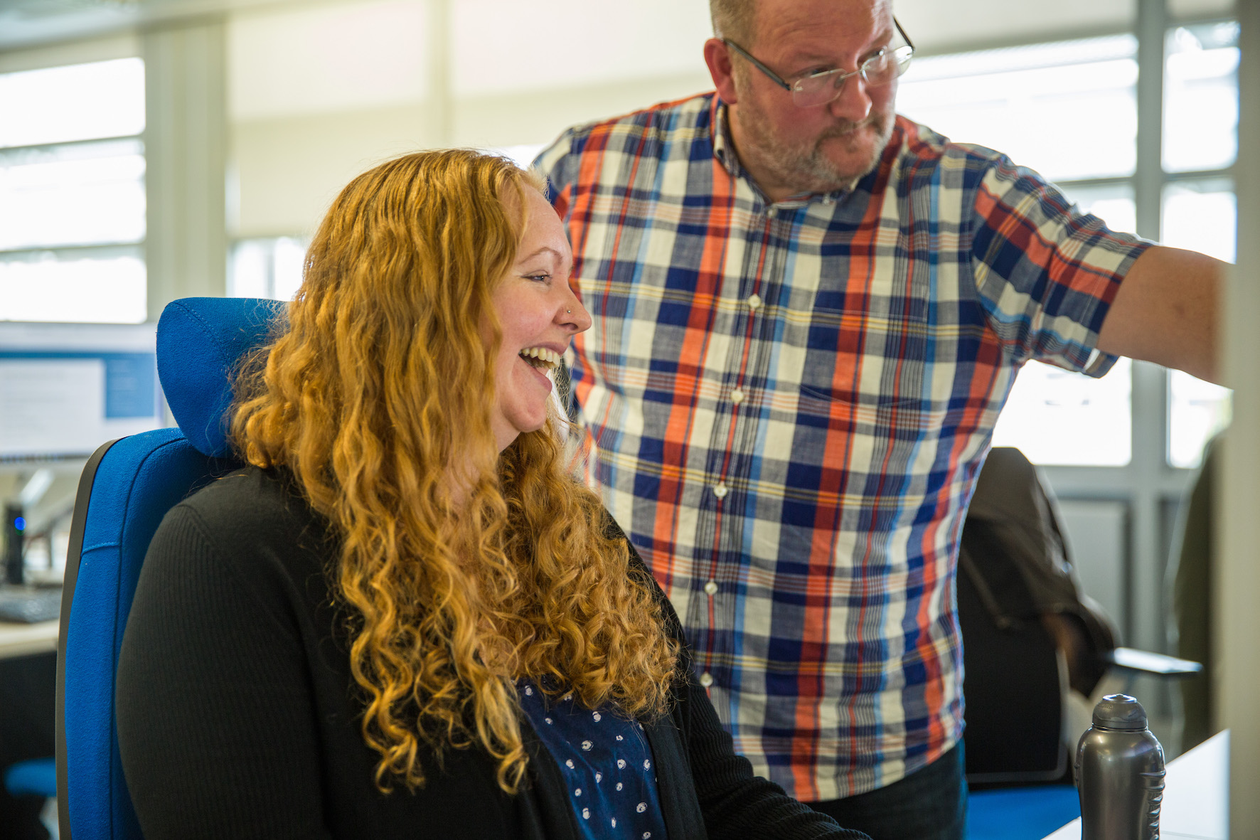 2 people talking at a computer screen