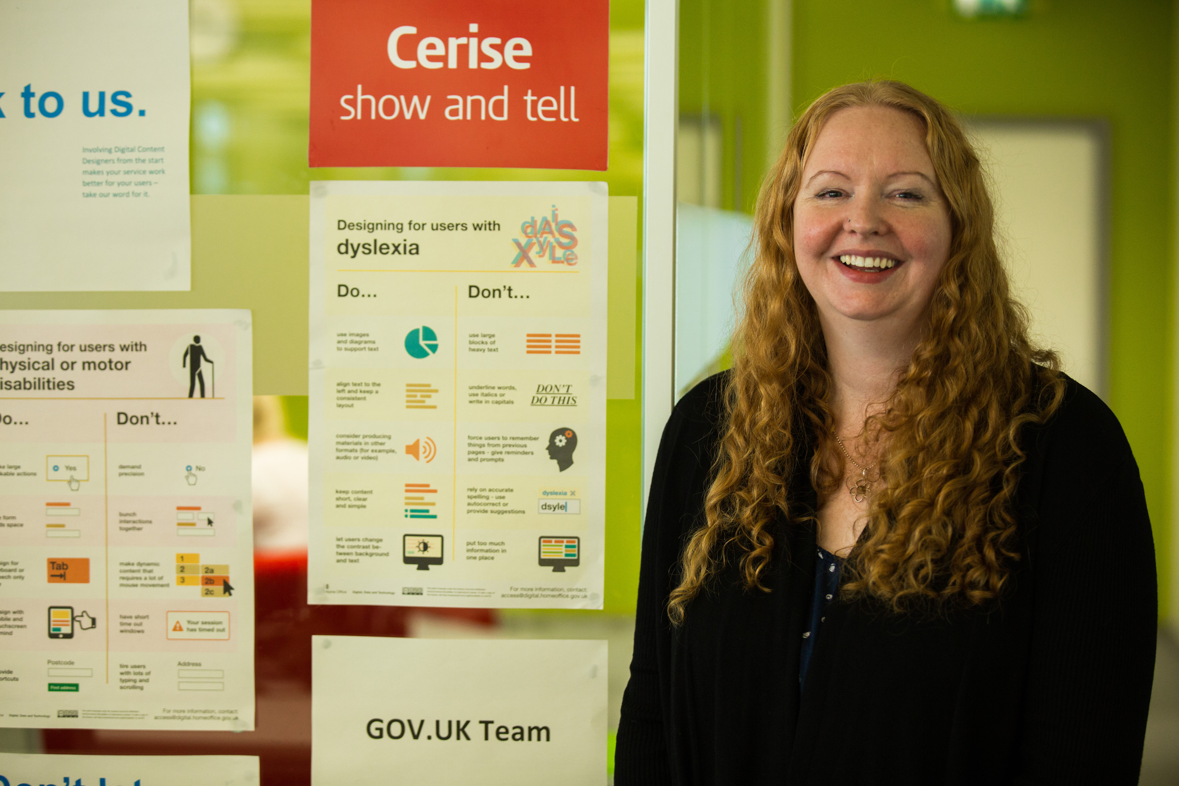 Jane standing next to a poster that has advice on designing for people with dyslexia