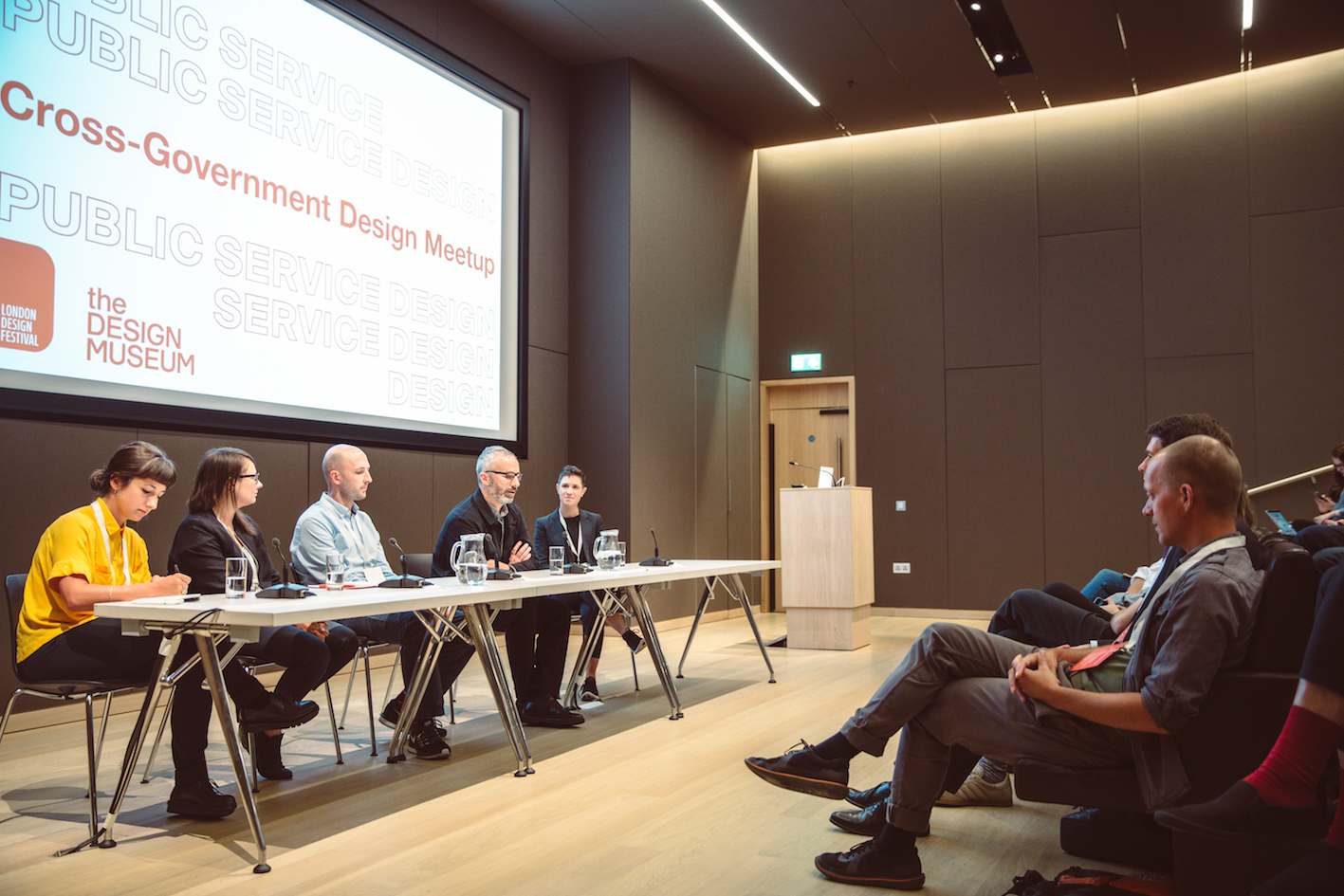 A panel of speakers in front of an audience