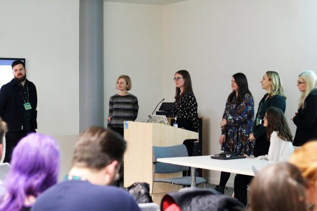 6 female designers from the Ministry of Justice presenting in front of their colleagues at a cross-government design meeting in London in February 2020