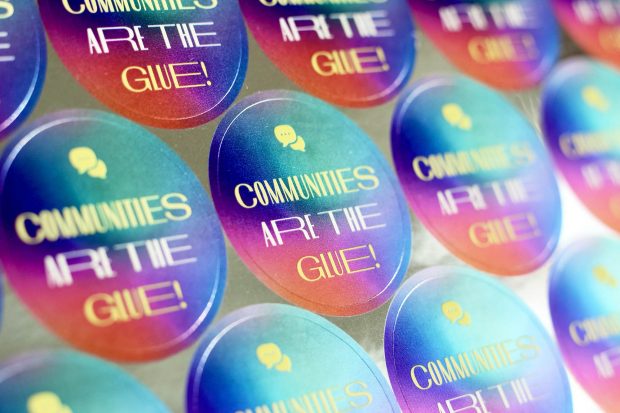 A sheet of colourful circular stickers all saying: Communities are the glue!