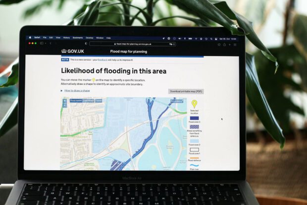 Laptop computer showing the flood map for planning service on GOV.UK with a map indicating the likelihood of flooding for a particular area
