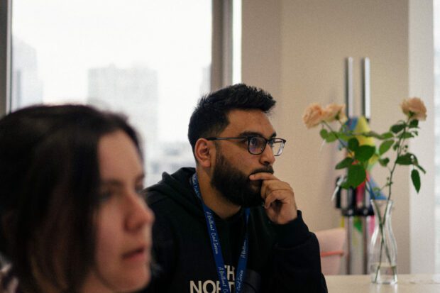 Two professionals in the GDS office sitting at a desk, as they focus on a presentation which is out of frame